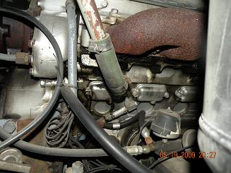 drivers side below exhaust manifold